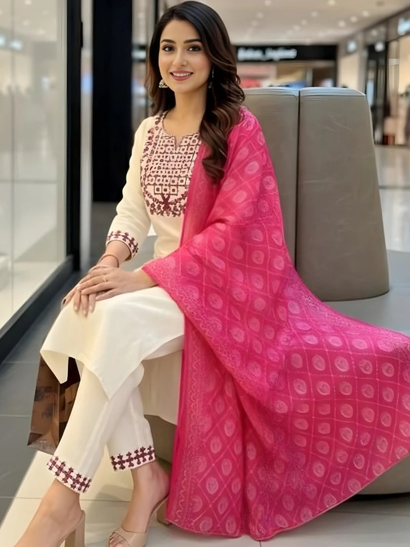 Woman in traditional outfit with pink dupatta sitting in a mall.