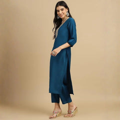 Woman wearing a teal kurta with a beige background