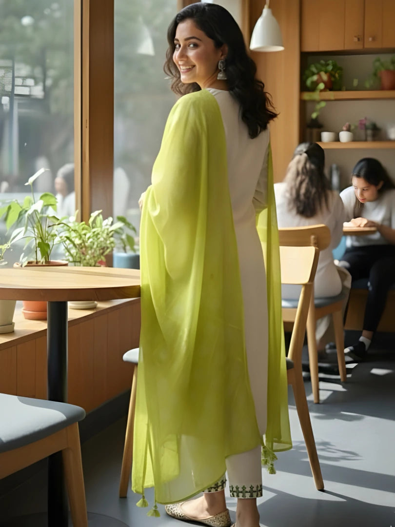 Woman in a bright yellow scarf standing in a modern cafe.