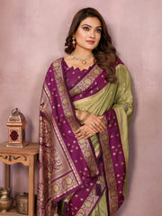 Woman wearing a traditional purple and green saree with a pink background