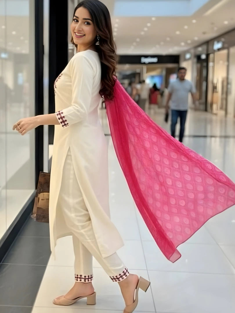 Woman in a white traditional outfit with a pink dupatta in a mall setting