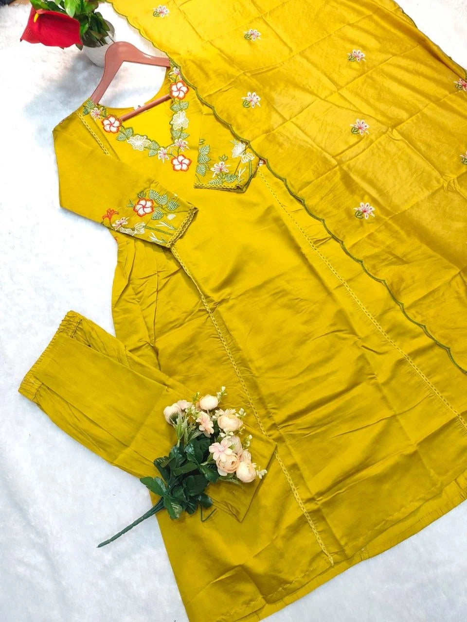 Yellow traditional outfit with floral embroidery on a white background