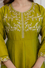 Green embroidered dress with gold details on a plain background