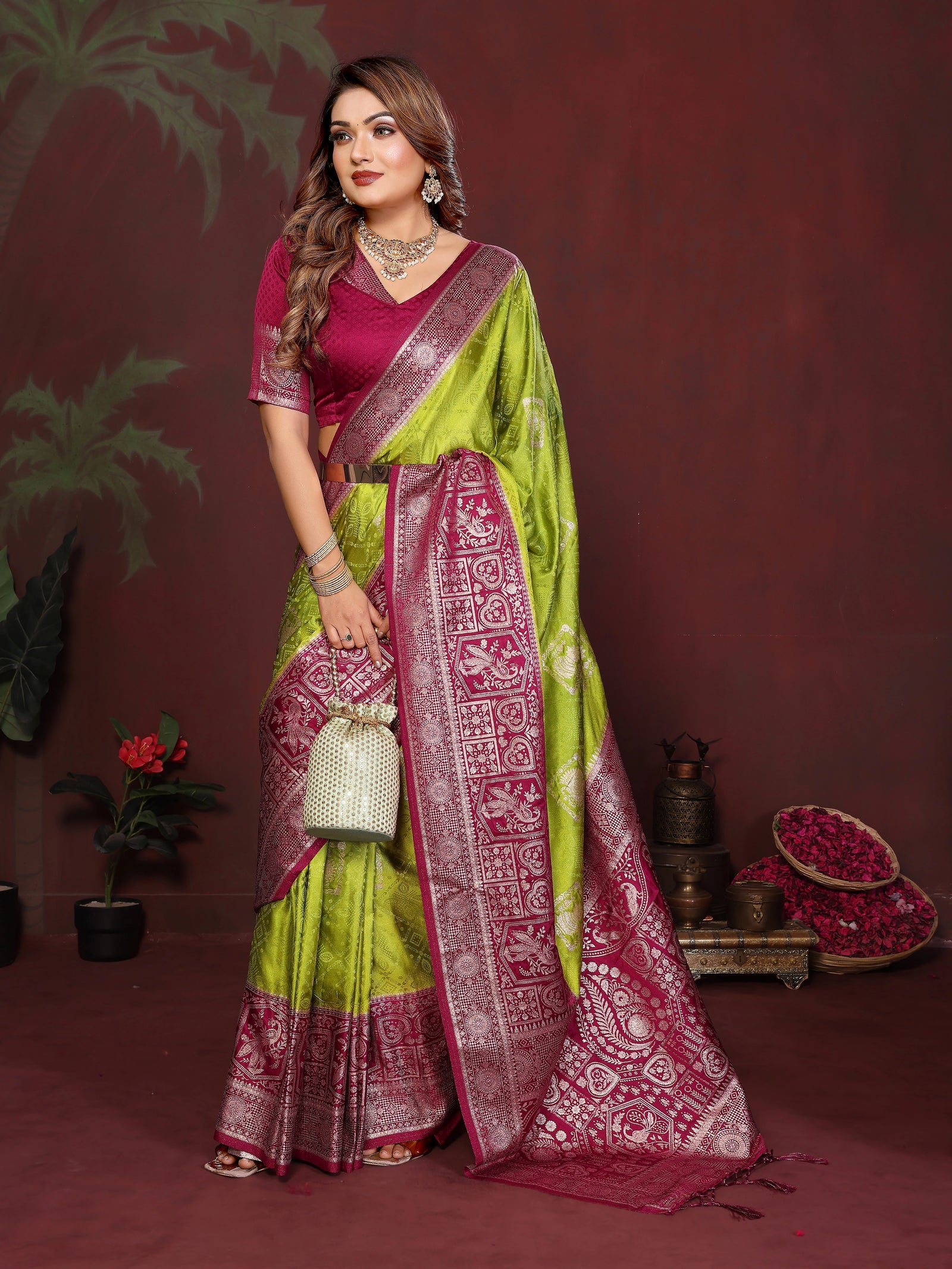 Woman wearing a green and pink saree with a dark background