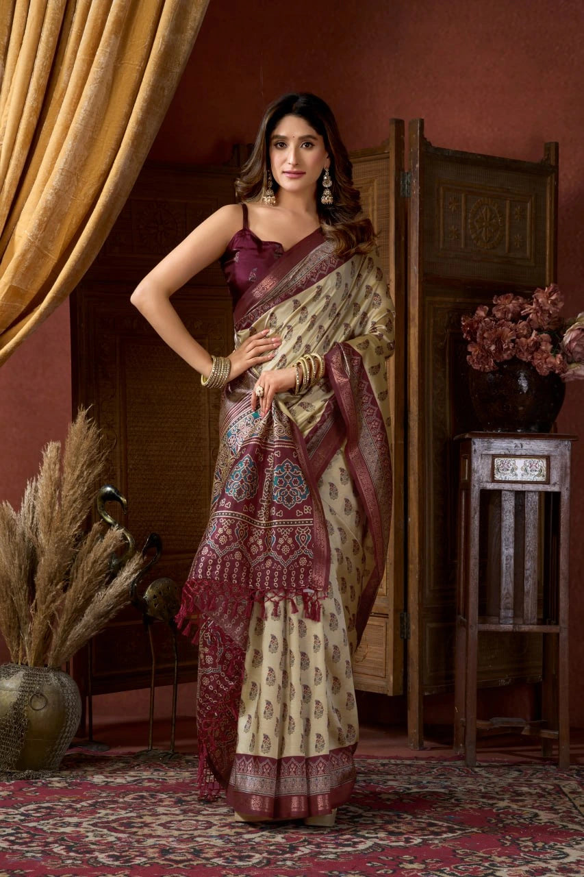 Woman in a traditional saree standing in a decorated room with a warm color scheme.