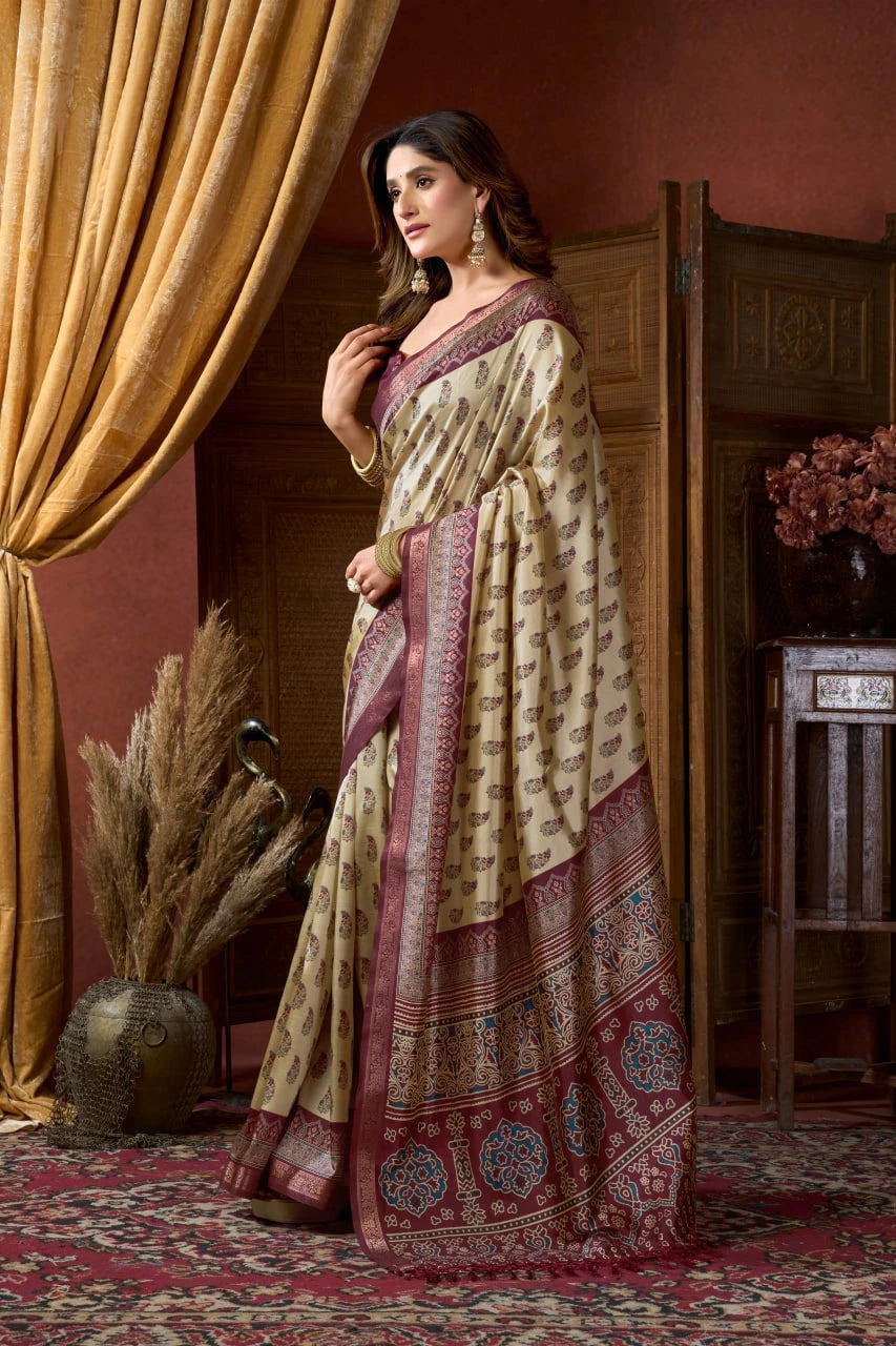 Woman in a traditional saree standing in an elegant room with gold curtains and decorative elements.
