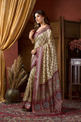 Woman in a traditional saree standing in an elegant room with gold curtains and decorative elements.