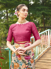 Elegant beige floral printed saree with magenta woven border and matching blouse in a scenic garden setting.
