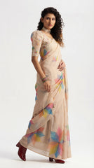 Woman wearing a beige saree with colorful patterns on a white background