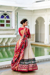 Woman in a traditional outfit standing in an elegant indoor setting with white walls and a pool.