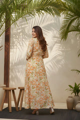 Woman in a floral dress standing in a sunlit room with plants