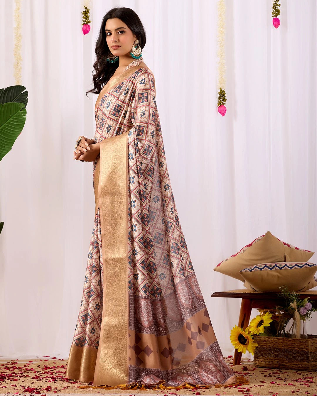 Woman wearing a patterned saree with a plain background