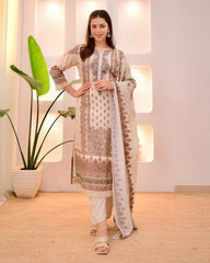 Woman in a traditional outfit standing in a well-lit room with plants.