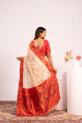 Woman wearing a red and beige saree with a white background