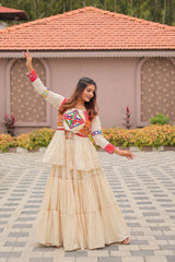 Woman in traditional outfit with colorful top and beige skirt standing on a paved area.