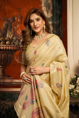 Woman in a beige saree with floral patterns in an indoor setting