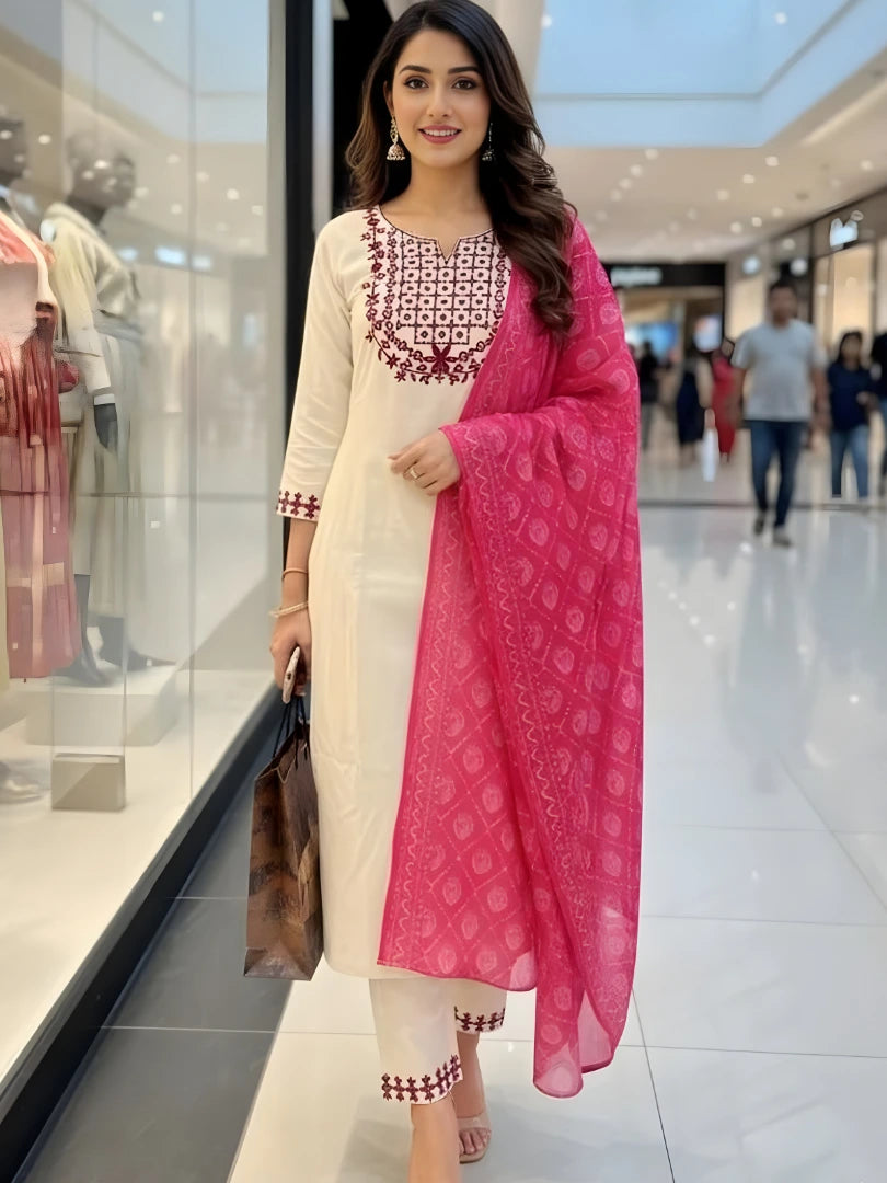 Woman in a white and pink traditional outfit standing in a mall.