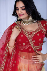 Woman wearing a red and gold embroidered blouse with a matching dupatta against a white background