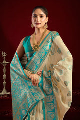 Woman wearing a traditional saree with a blue and beige pattern against a dark background