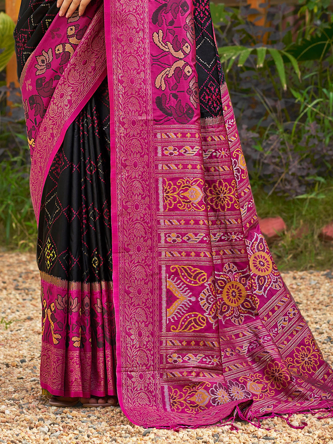 Black and pink saree with intricate patterns on a natural background