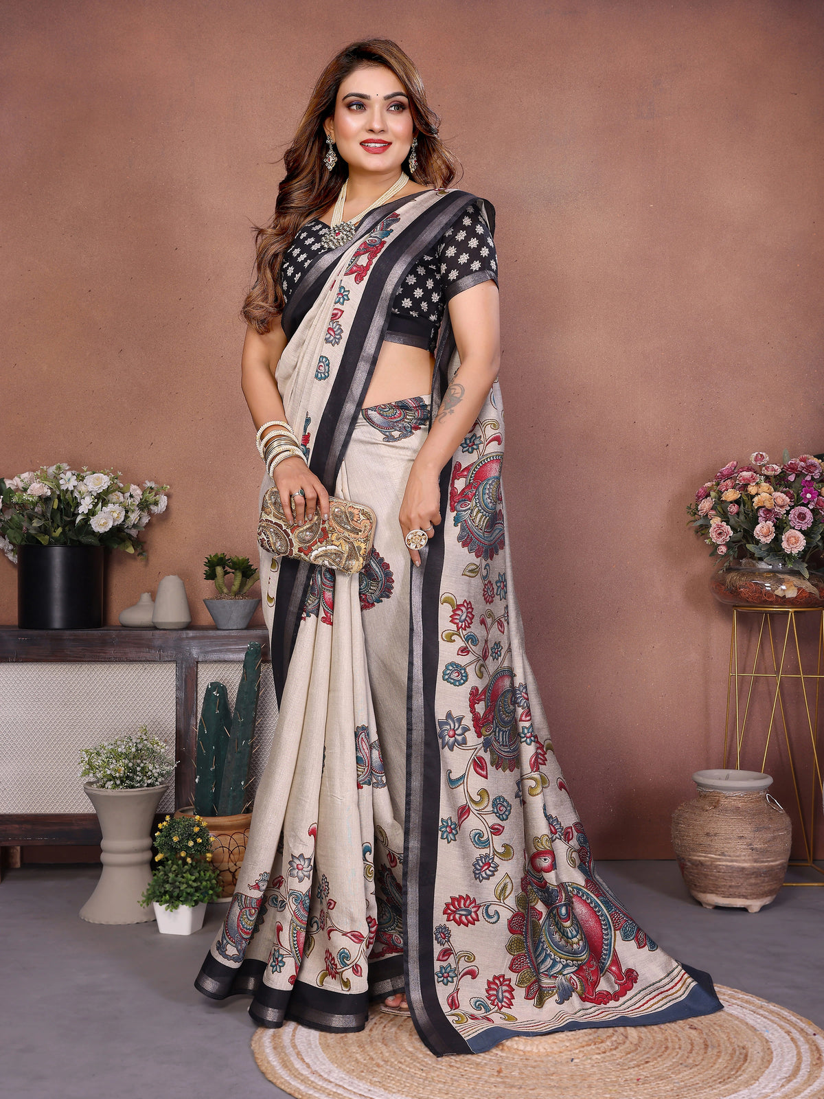 Woman wearing a floral saree with a black blouse in an indoor setting.