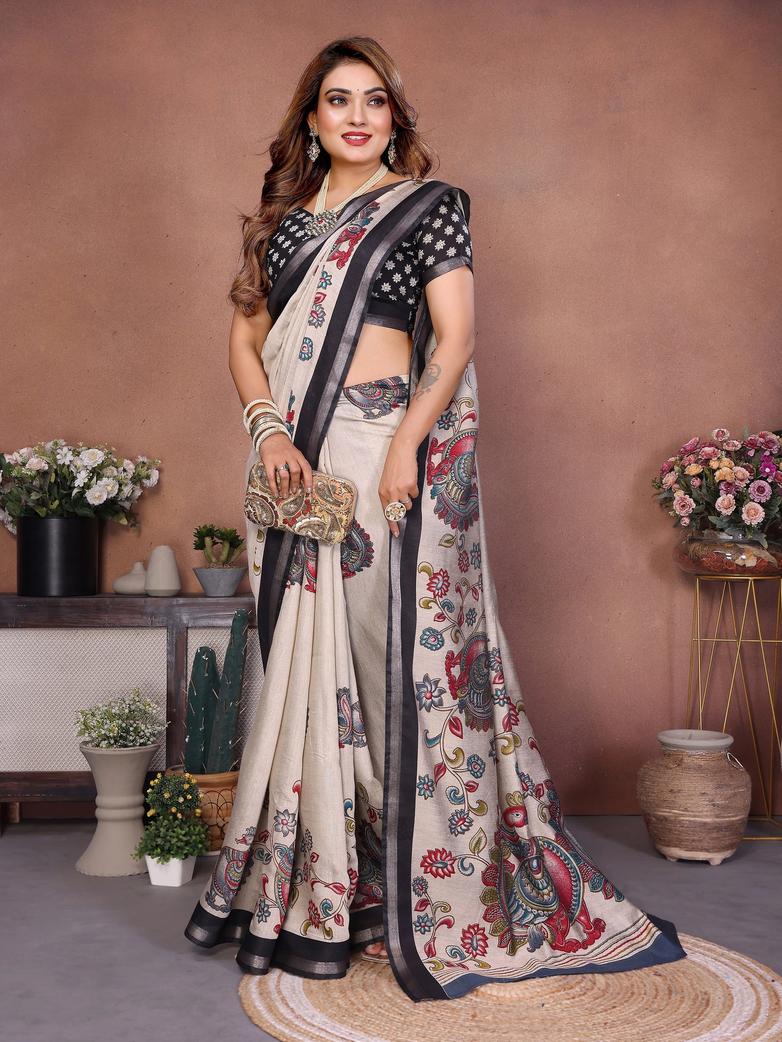 Woman wearing a floral saree with a black blouse in an indoor setting.
