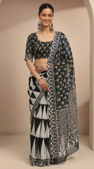 Woman wearing a black and white patterned saree against a beige background