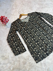 Floral-patterned shirt on a hanger against a textured white background