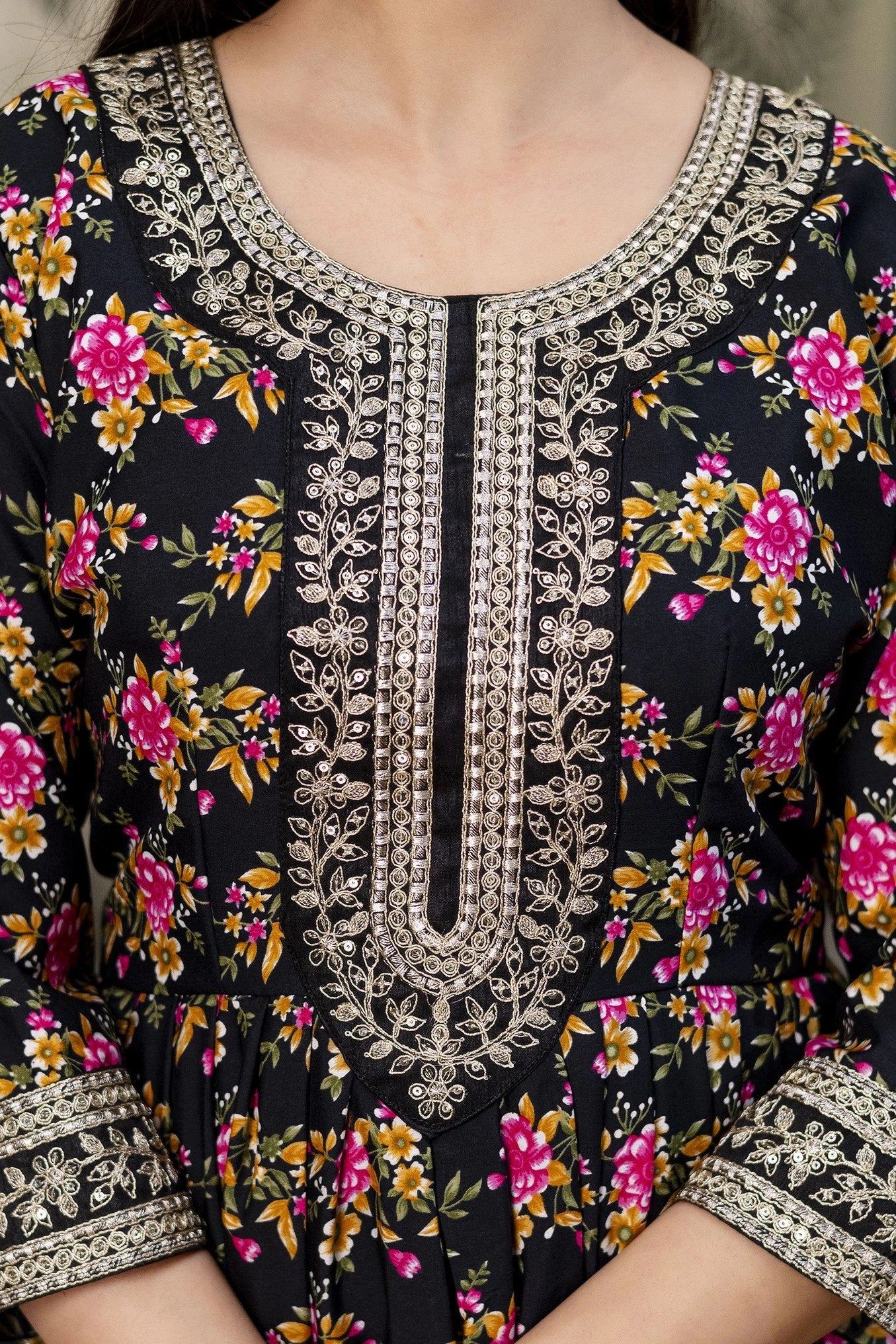 Close-up of a black floral dress with intricate silver embroidery