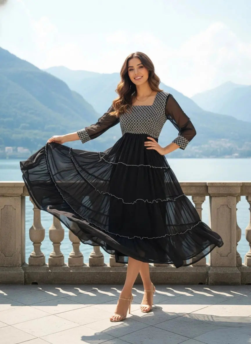 Woman in a black and white dress standing on a balcony with mountains and water in the background