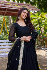 Woman in a black traditional outfit with a decorative scarf outdoors