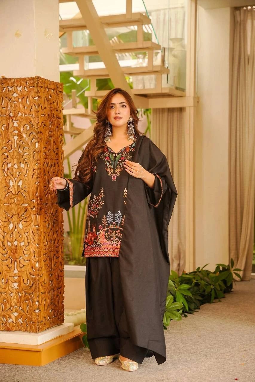 Woman in traditional outfit standing indoors with decorative elements.