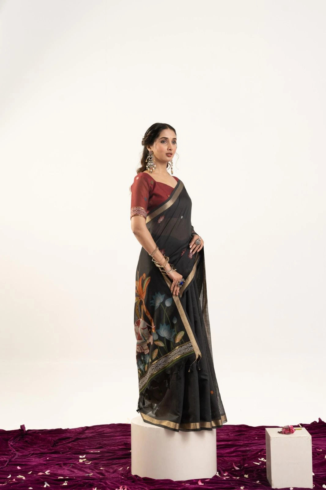 Woman in a black saree with a floral pattern on a white background