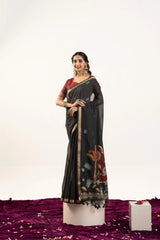 Woman wearing a black saree with floral patterns on a white background