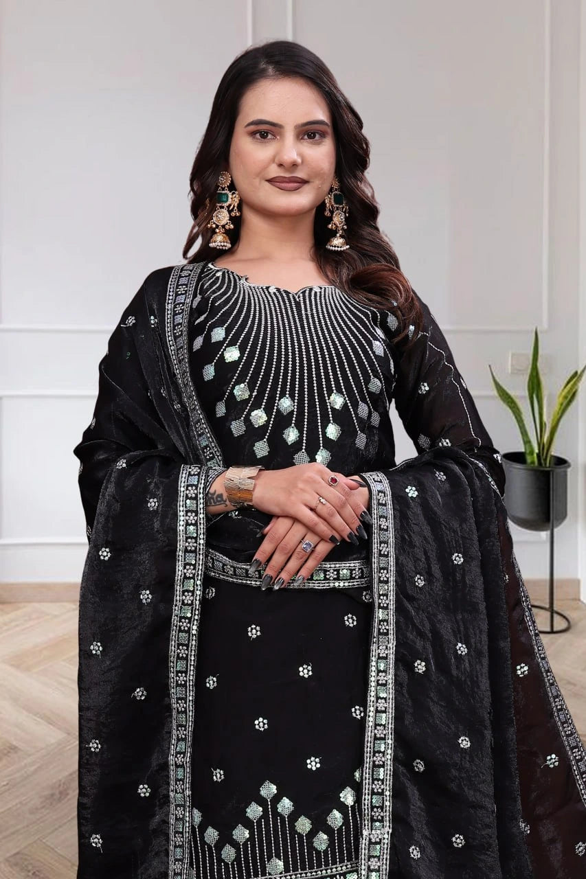 Woman wearing a black and white embroidered traditional outfit with a white background