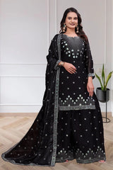 Woman wearing a black embroidered traditional outfit with a white background