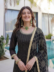 Woman in traditional black and gold outfit with jewelry by a pool