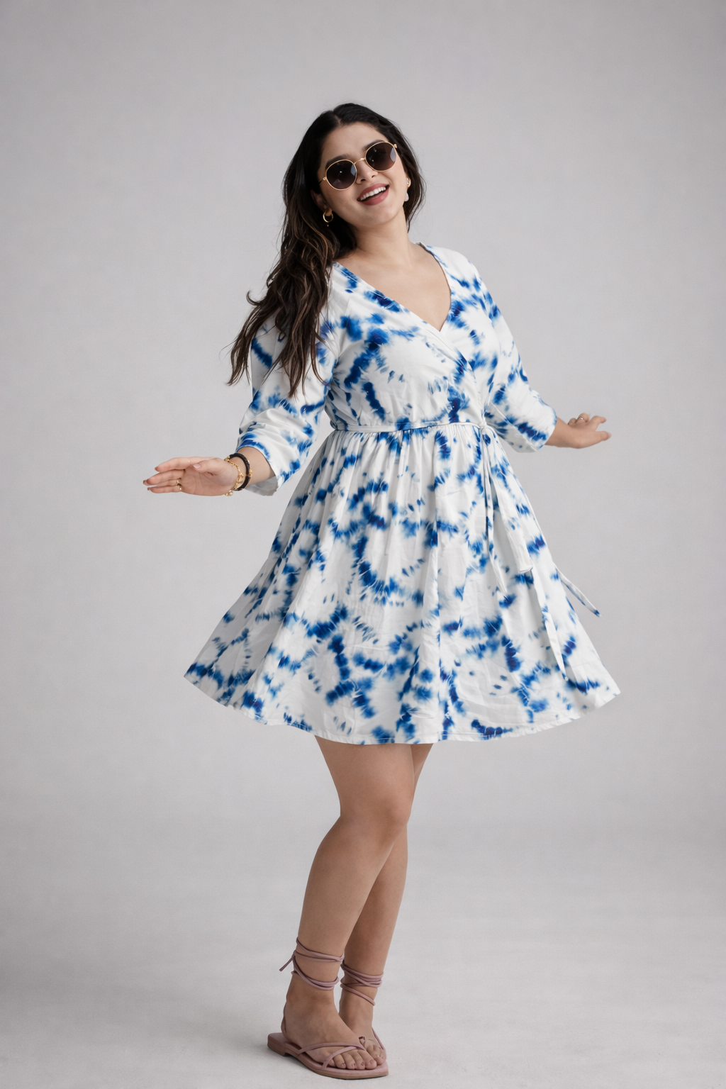Woman wearing a blue and white tie-dye dress on a gray background