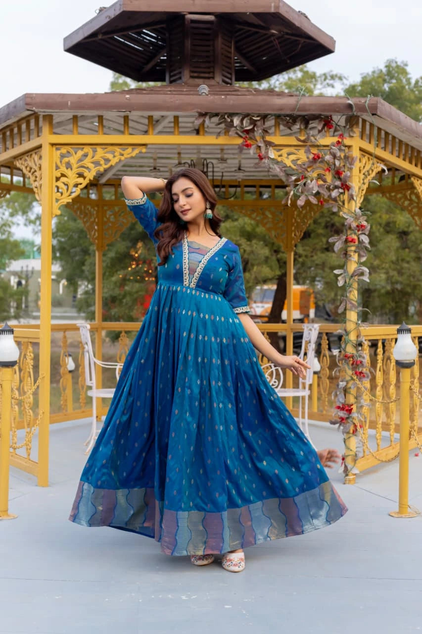 Woman in a blue dress posing in front of a decorative gazebo.