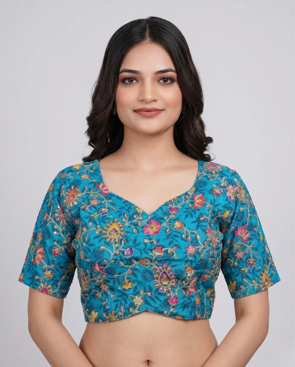 Woman wearing a blue floral blouse against a plain background