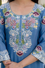 Close-up of a blue embroidered garment with floral patterns