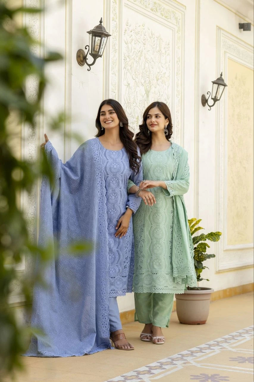 Two women in traditional outfits standing in a well-lit room with decorative elements.