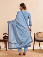 Woman wearing a light blue traditional outfit with a matching dupatta in a room setting.