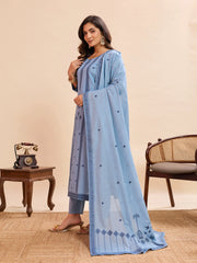 Woman wearing a light blue traditional outfit with a matching dupatta in a room setting.