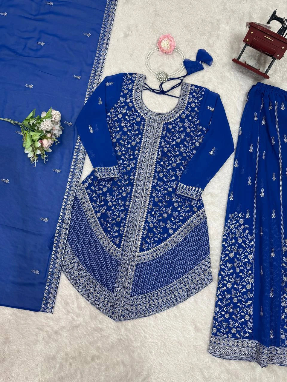 Blue embroidered traditional outfit with matching dupatta on a light gray background