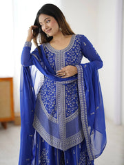 Woman wearing a blue embroidered traditional outfit with a white background