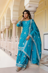 Woman in a blue traditional outfit standing in an architectural setting