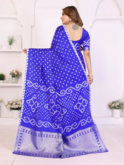 Woman wearing a blue saree with white patterns in a minimalistic setting