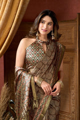 Woman in traditional attire standing in a decorated room with wooden paneling and curtains.