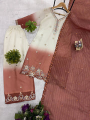 Traditional outfit with a white and brown dress on a hanger against a light background.